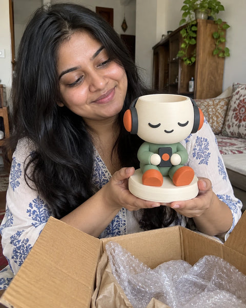 A MiniKin customer lifting a Headphone Planter out of its packaging