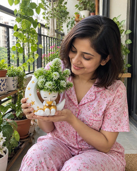 MiniKin Festival Moon Planter with its artificial plant on a balcony full of plants
