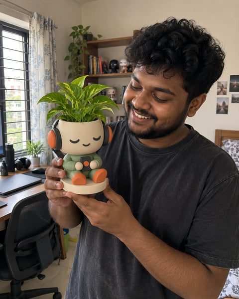 Man smiling at the MiniKin Headphone Planter with a plant in his room